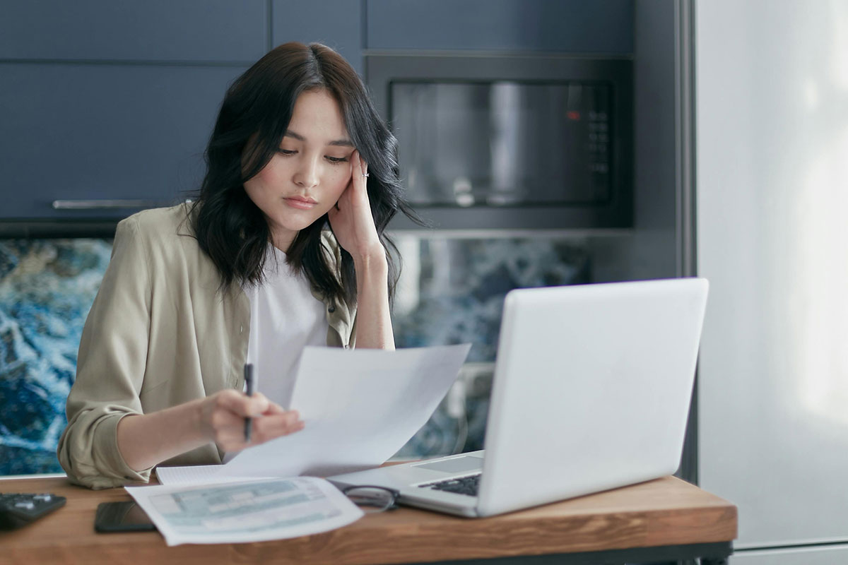 Uninsured adult reviewing medical bills and low-cost healthcare options at home.